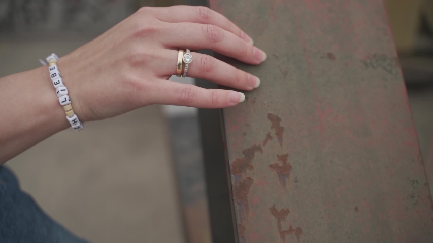 Close-up tracking shot of a lady's hand wearing diamond ring while sensually feeling a plaque of vintage rustic iron wood | Shutterstock HD Video #1036797944