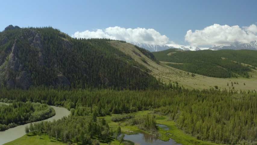 Beautiful spring landscape with mountains, forest and river. Aerial View. Drone shot over a beautiful mountain forest river.