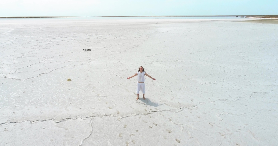 Happy young girl standing on a dry salt lake