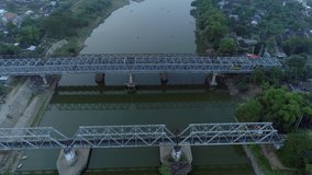Aerial footage drone parallax tilting down slowly with point of interest steel bridge and Bengawan Solo river