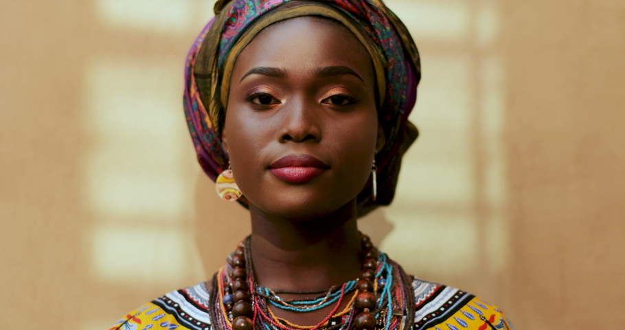 Portrait of African American young charming and happy woman in the scarf on her head and traditional look laughing to the camera. Close up face  Royalty-Free Stock Footage #1036839071
