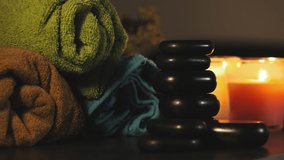 Colours towels, hot stones and candles for relax spa massage and body treatment. Beautiful composition with candles and hot stones. Spa and wellness concept with ambient light - Powered by Shutterstock - Get 15% off with code: PIKWIZARD15