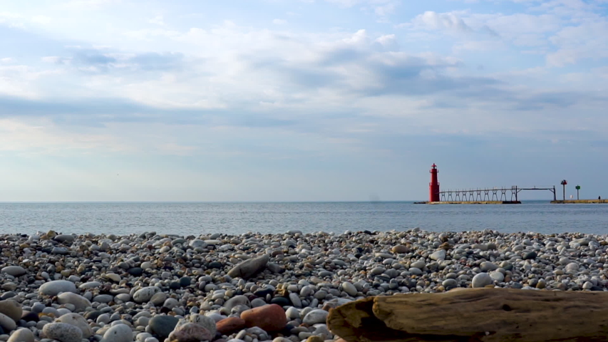 Driftwood on the Shore at Pierhead Lighthouse on Cresent Beach in Algoma Wisconsin, Establishing shot