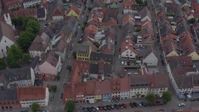 Aerial view of the old town of Kenzingen in Germany on a cloudy day in the afternoon. Round pan to the left above the church.
