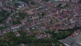 Aerial view of the old town of Kenzingen in Germany on a cloudy day in the afternoon. Wide view with tilt up an slow descend.