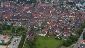 Aerial view of the old town of Ettenheim in Germany on a cloudy day in the afternoon. Very wide view with pan to the right.