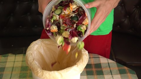 Man throws vegetable peeling, scraps and fruit peels in a compost bucket. Food waste reduce. Sorting of household waste, composting, recycling, zero waste