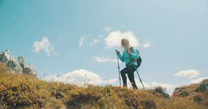 Woman tourist traveler walking on the top of mountain in summer sunny day under sun light. Beautiful mountains landscape view. 4K slow motion video

