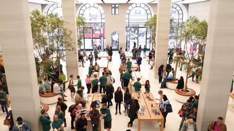 London, United Kingdom - Circa 2019: Hundreds of people walking between iMacs iPad Apple Watch Mac Pro and iPhone products inside Apple Computers Store on Regent Street elevated view from above view