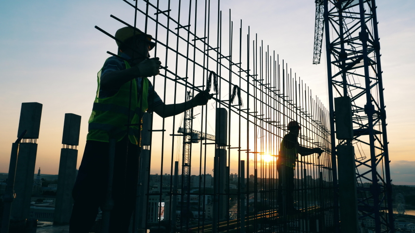 Construction workers are making a metal framework at sunset | Shutterstock HD Video #1036873028