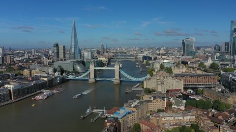 Aerial view of cityscape of London, Tower Bridge and Tower of London, skyscrapers skyline of City of London in background, clear blue sky - panorama of Great Britain from above, United Kingdom, Europe