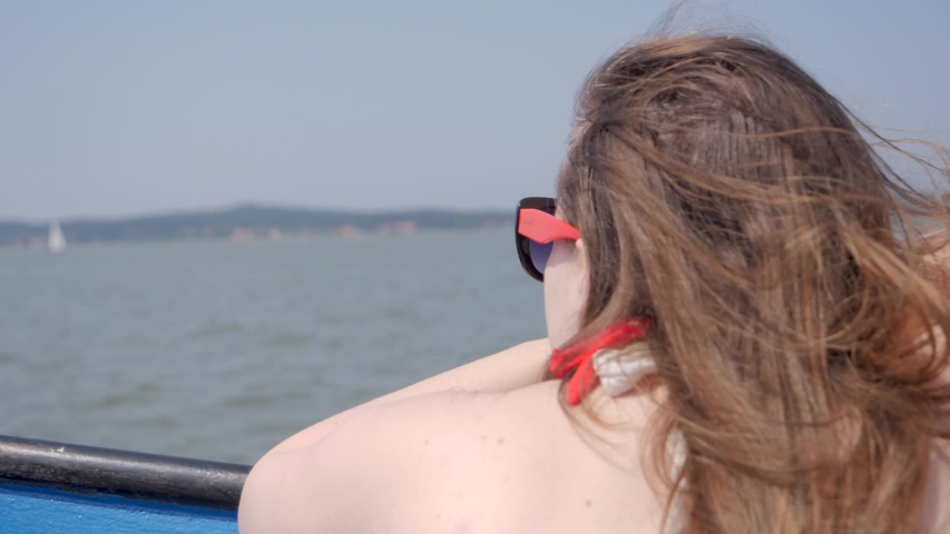 Young woman watching yachts on the water. RACK FOCUS, SLOW MOTION