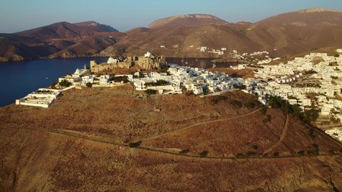 Aerial drone video of iconic medieval fortified castle overlooking the deep blue Aegean sea in Chora of Astypalaia island, Dodecanese islands, Greece