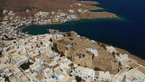 Aerial drone video of iconic medieval fortified castle overlooking the deep blue Aegean sea in Chora of Astypalaia island, Dodecanese islands, Greece