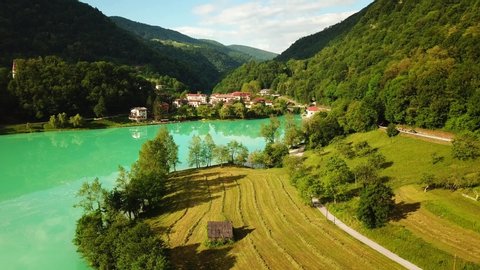 Forward drone shot above a slovenian valley, with a river flowing surrounded by mountains