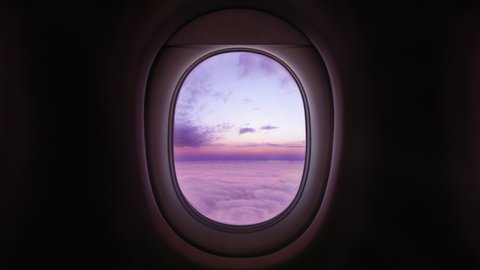 Airplane Window View Above the Clouds at Sunset