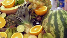 Fresh tropical fruit display on a buffet with citrus, watermelon, grapes, pineapple, bananas and melon
