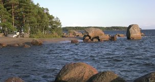 4K summer late afternoon high quality video of Santalahti Baltic Sea Finnish Bay lagoon, pine tree forest beach with red granite boulders, lone island beach near Kotka, Finland Suomi, northern Europe