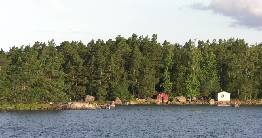 4K summer morning high quality video of Santalahti Baltic Sea Finnish Bay lagoon, pine tree forest beach with red granite boulders, lone island beach near Kotka, Finland Suomi, northern Europe