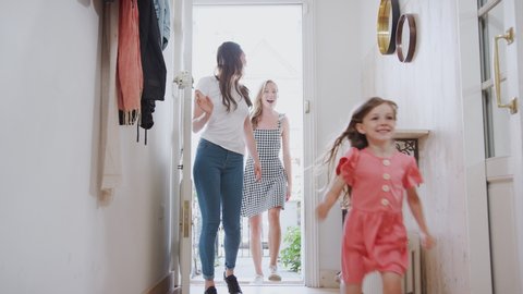 View Inside Hallway As Same Sex Female Couple With Daughter Open Front Door Of Home