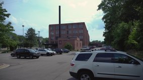 4k Shot looking onto an industrial factory in Grand Rapids, Michigan. Color corrected. Clip is 30 seconds in length and features the building as well as surrounding parking lot, cars, and trees.
