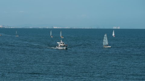 Sailboats sailing at sea and sportfishing boat cruising in the opposite direction