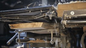 Sawmill. Woodworking enterprise. Wood processing. The jointer machine processes a wooden board. The video contains sound.
