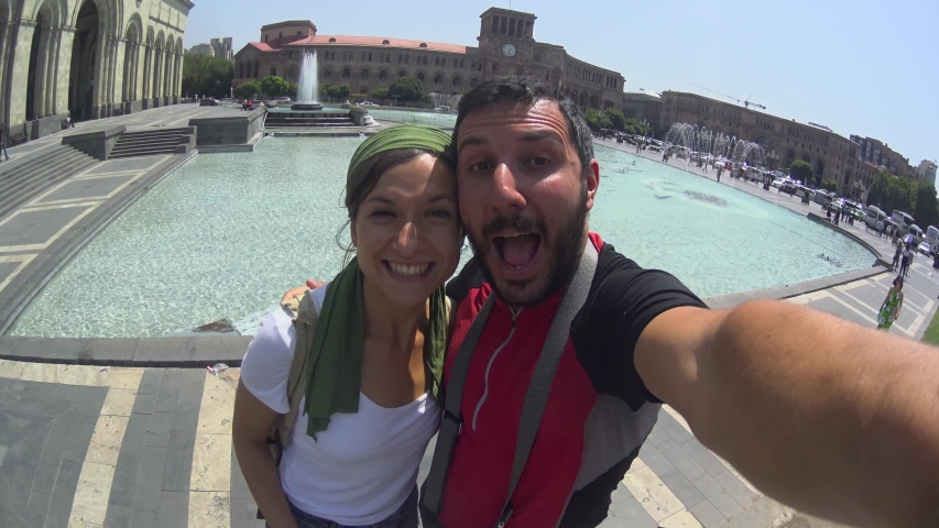 happy tourist couple in Armenia, taking selfie in Yerevan city in the main square of the republic