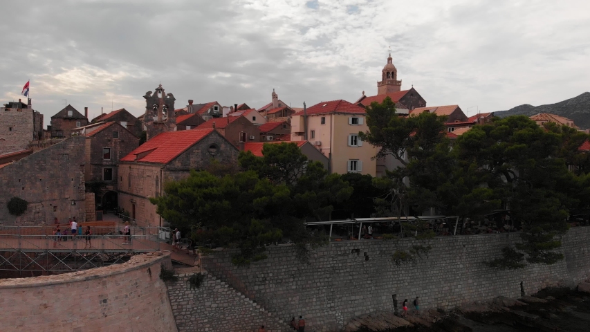 The centre of Korcula with people on the shore and the streets - aerial slide