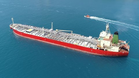 Supertanker loaded with full of oil underway in the open sea. Oil chemical tanker ploughs through the water. Aerial tracking video of a 182 meters long tanker ship
