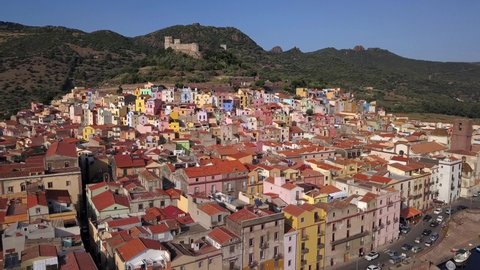 Bosa - Drone aerial shot, point of interest flying over the colourful town of Bosa and the castle on the hill top