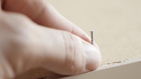 Close-up of nail holding while hammering 4K shallow DOF video