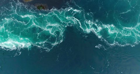 4K slow motion drone video with birds-eye view of the abstract and powerful water currents, rapids and whirlpools of the worlds larges maelstrom Saltstraumen in Bodo, Norway.