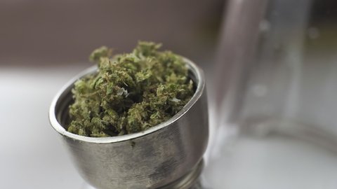 Close-up of smoking medical marijuana with bong, indoors. Macro of smoke cannabis at home. Cannabis is a concept of herbal medicine.
