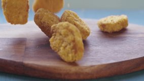 vegan plant based nuggets falling on cutting board in slow motion - Powered by Shutterstock - Get 15% off with code: PIKWIZARD15