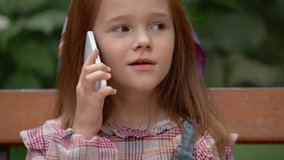 emotional child talking on smartphone in park
