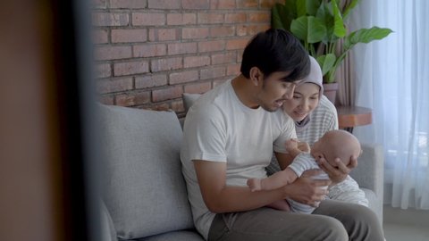 happy muslim parent with their newborn baby at the livingroom together