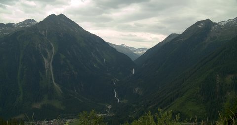 Establishing shot of the Zillertal mountain region with the Krimml waterfalls seen on the other side of the Valley.