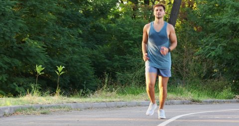 Young man suffering from knee pain during running in park