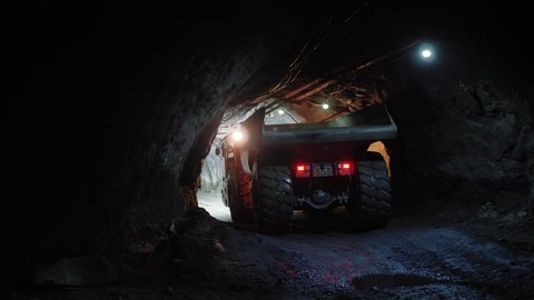 Mining truck moves inside dark tunnel in copper pyrite mine. Huge heavy mining machinery transporting rock.
Rear brake lights of excavator. 