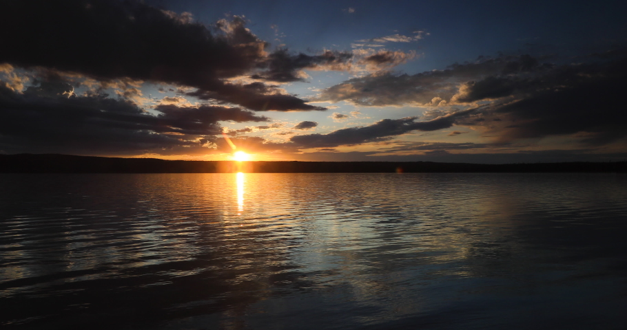 Yellowstone brilliant dark sunset over lake and forest. Beautiful sunset high Rocky Mountain. Pine forest nature, serenity and peace landscape environment. Geography, geology, natural beauty.