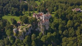 Aerial view around the Lichtenstein Castle in Germany on a sunny day in Summer. Pan to the left beside the castle.