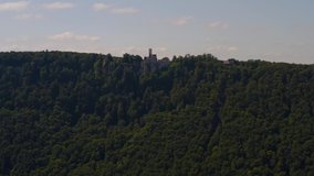 Aerial view around the Lichtenstein Castle in Germany ona sunny day in Summer. Tilt down from the castle to the valley.