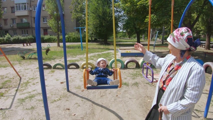 Disabled grandmother on a swing with grandson boy