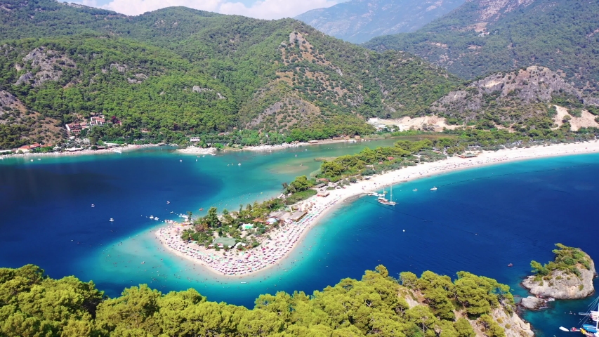 Oludeniz is a resort village on the southwest coast of Turkey. It’s known for the blue lagoon of Oludeniz Tabiat Parki and the wide, white Belcekiz Beach. Royalty-Free Stock Footage #1036985696