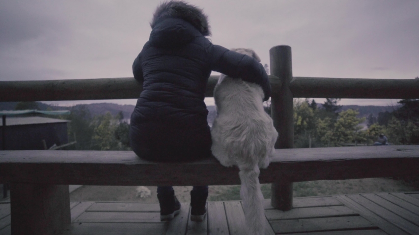 HD of a woman and her dog outdoog house in front of a lake (house)