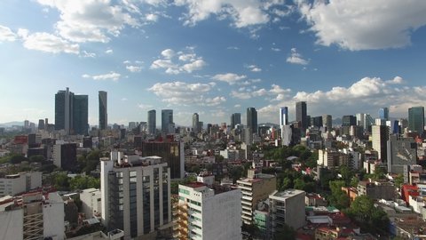 Aerial panoramic view of the skyline in Reforma Avenue, in Mexico City, on a clear day with blue sky. Drone slowly flying forward
