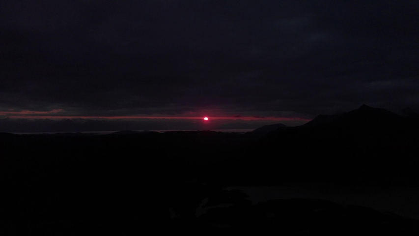 Red Alaskan Sunset between clouds and horizon