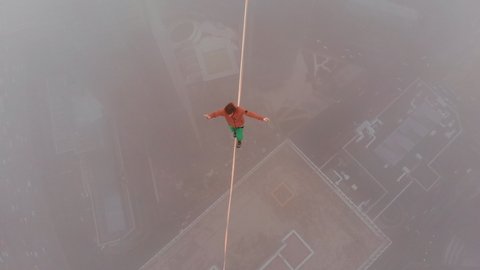 Slackline world record in Moscow, Guinness world record. A man balances on tight rope, a view of the city from height in mist.