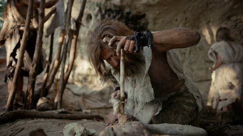 Primeval Caveman Wearing Animal Skin Trying to make a Fire with Bow Drill Method. Kindle First Man-Made fire in the Human Civilization History. Making Fire for Cooking. Slow Motion